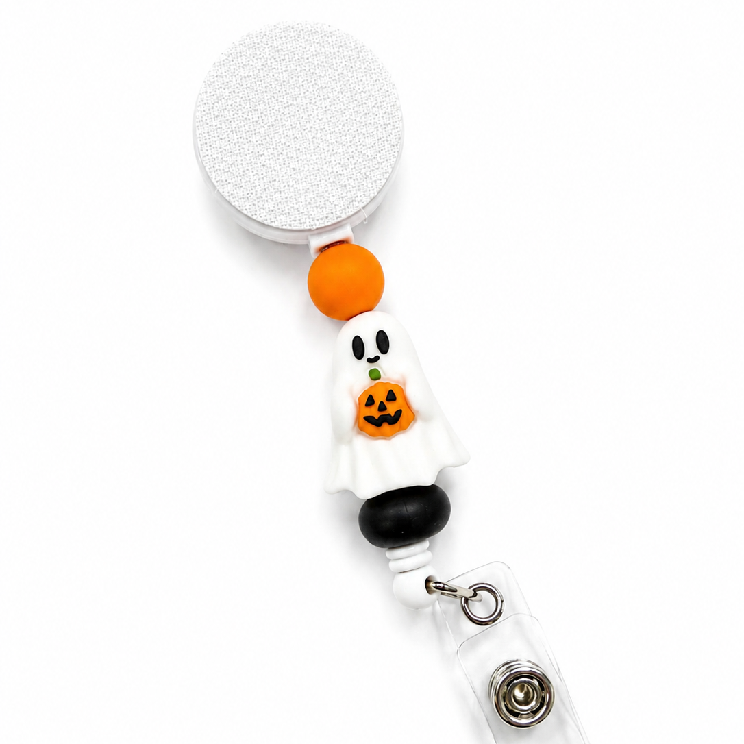 Ghost With Pumpkin badge reel featuring a white ghost holding a smiling jack-o'-lantern with orange, black, and white decorative beads on a retractable badge reel.