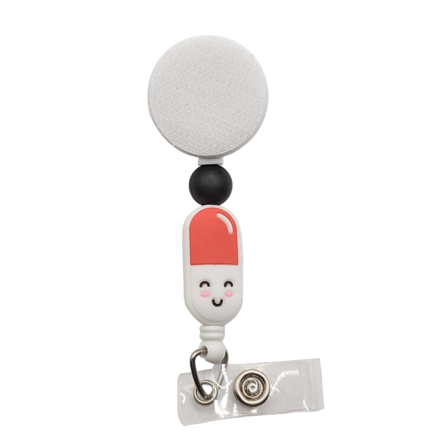 Happy pill badge reel with a smiling red and white medicine capsule topper, black silicone bead, and white retractable badge reel for nurses, pharmacists, and healthcare workers.