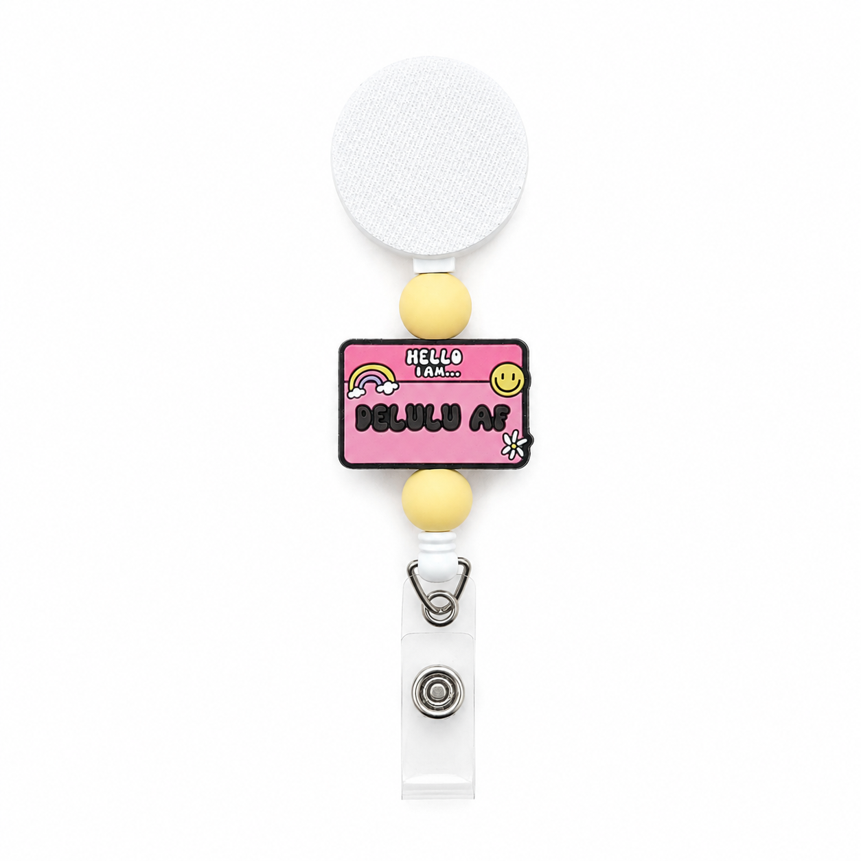 Hello I Am Delulu AF beaded badge reel with yellow silicone beads, pink name tag focal, rainbow, smiley face, and daisy on a white retractable badge reel.