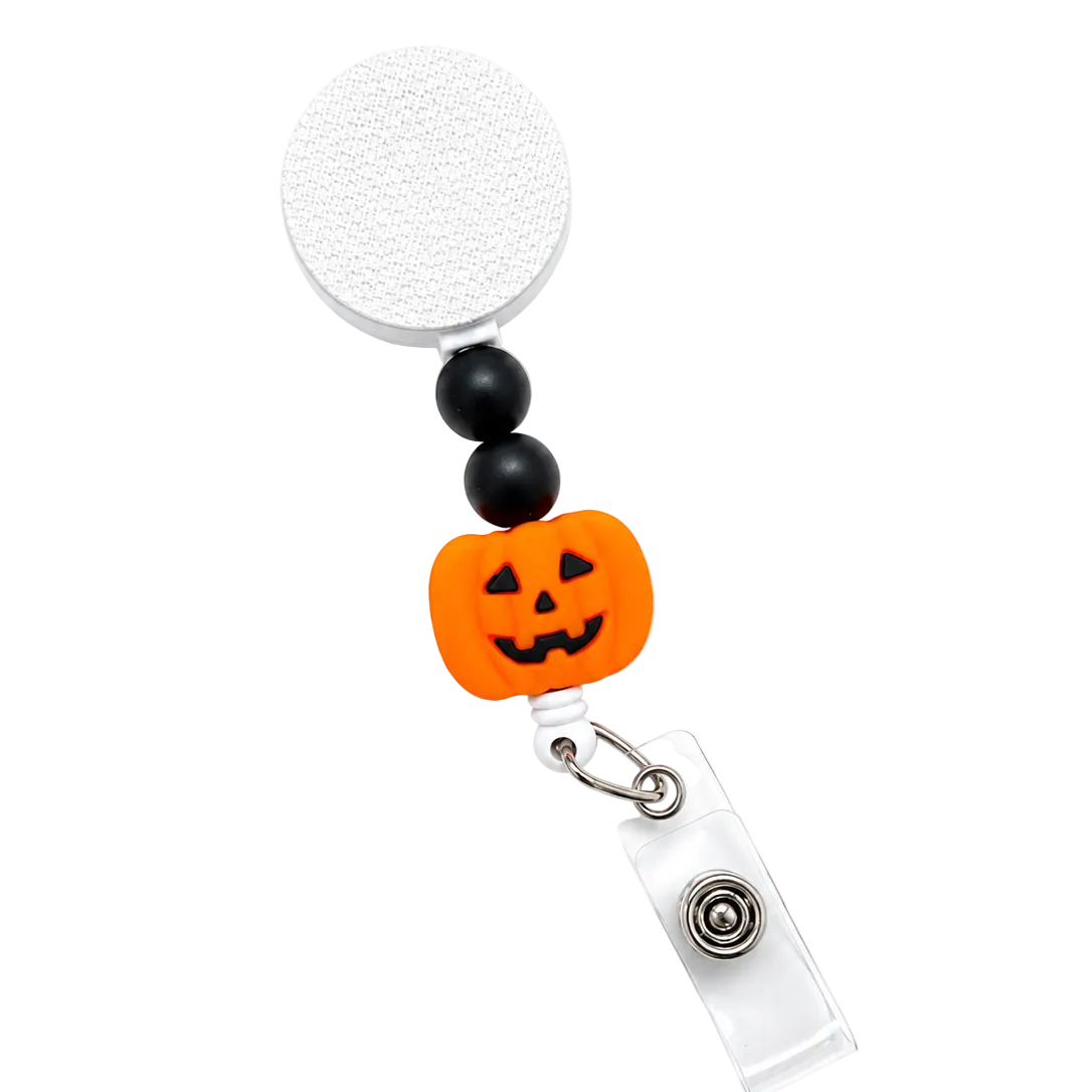 Jack-o'-Lantern badge reel featuring a smiling orange pumpkin with black decorative beads, retractable badge reel, and secure badge holder attachment for Halloween workwear.