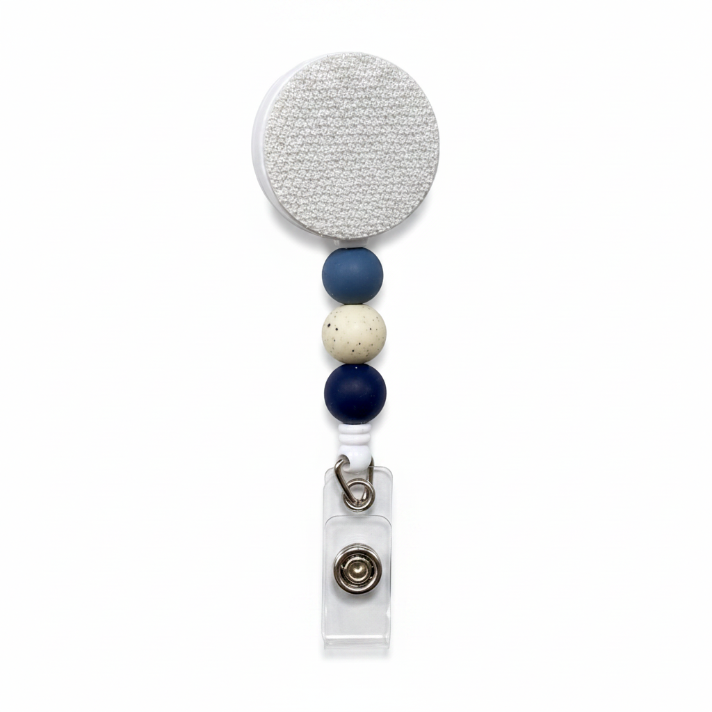 Mountain Lake interchangeable badge reel with slate blue, speckled ivory, and navy silicone beads on a white retractable badge reel for everyday work.
