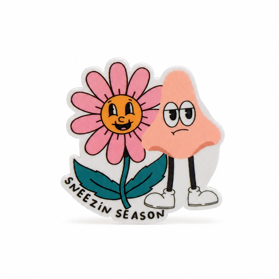 SNEEZIN SEASON allergy plastic add-on with a smiling pink flower and grumpy cartoon nose, compatible with interchangeable badge reel bases.