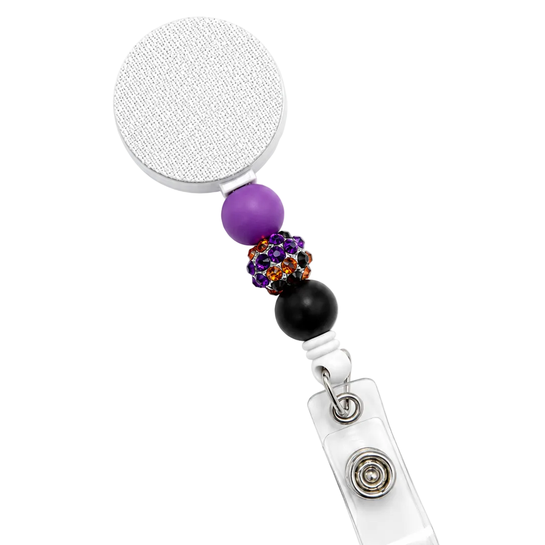 Witch's Brew badge reel featuring purple, black, and orange rhinestone accent beads with black and purple decorative beads, a retractable badge reel, and secure badge holder attachment.
