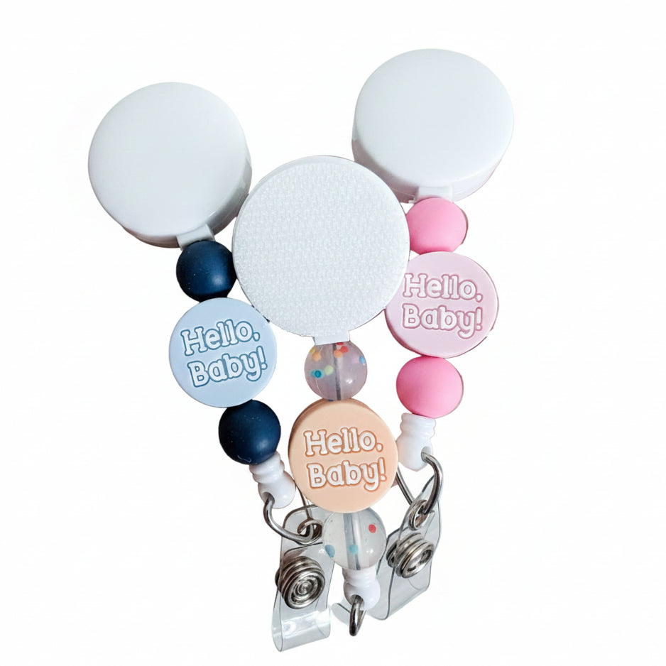 Hello, Baby! beaded badge reel with pastel silicone beads and confetti accent bead, retractable interchangeable badge reel compatible with plastic and hardboard add-ons, available in blue, peach, and pink.