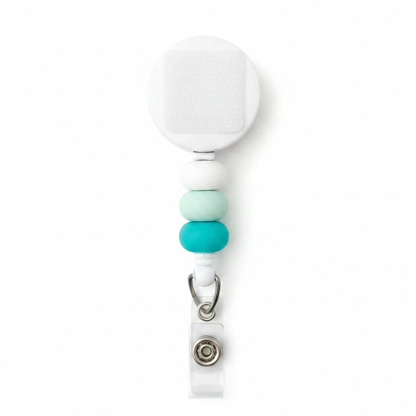 Minimalist interchangeable badge reel featuring white, mint, and aqua beads with a retractable badge holder for nurses, teachers, office staff, and healthcare workers.