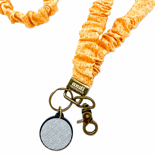Bloom Interchangeable Andi Lanyard featuring a golden yellow floral fabric pattern, interchangeable badge lanyard compatible with interchangeable hardboards and plastic add-ons.