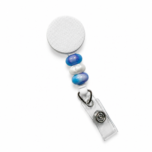 Blue and white beaded badge reel with decorative ombre bead accents, retractable badge reel design, and secure badge holder attachment for everyday work use.