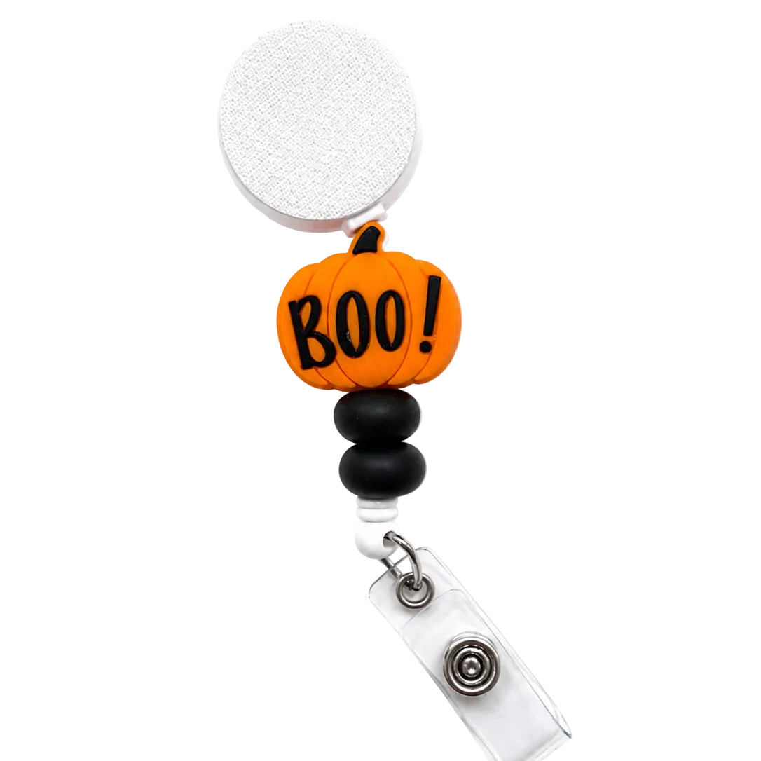 Boo! Pumpkin badge reel featuring an orange pumpkin with the word "BOO!", black decorative beads, a retractable badge reel, and secure badge holder attachment for Halloween workwear.