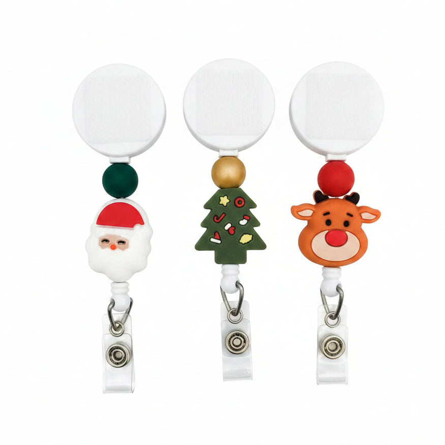 Christmas badge reel available in Santa, Christmas tree, and red-nosed reindeer designs with green, gold, or red beads and white retractable reels.