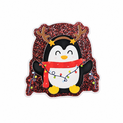 Christmas penguin plastic add-on with reindeer antlers, red scarf, colorful holiday lights, and glitter-inspired background, compatible with interchangeable badge reel bases.