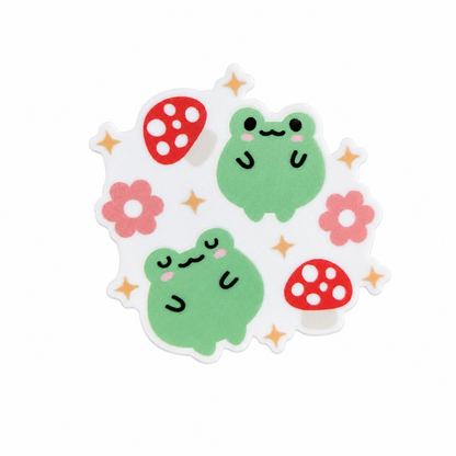 Cute Frog Mushroom plastic add-on with two green frogs, red mushrooms, pink flowers, and sparkle accents, compatible with interchangeable badge reel bases