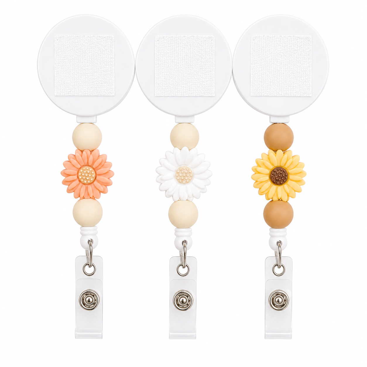 DAISY badge reel available in peach, white, and mustard yellow featuring a floral daisy focal charm, coordinating silicone beads, and an interchangeable retractable badge reel.