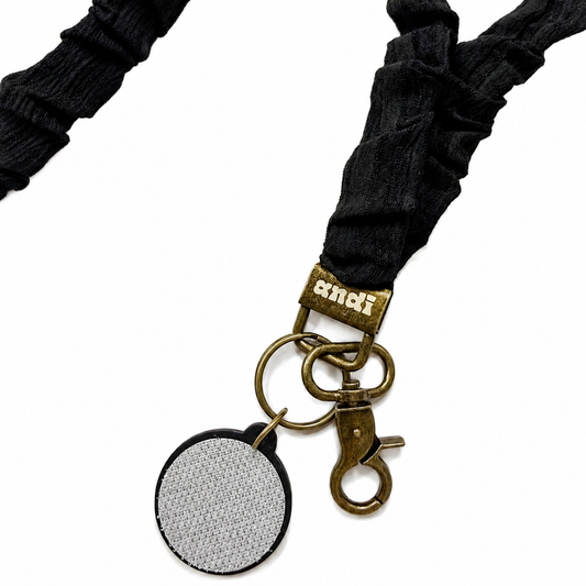 Eclipse Interchangeable Andi Lanyard featuring a solid black scrunchie-style fabric design, compatible with interchangeable hardboards and plastic add-ons.