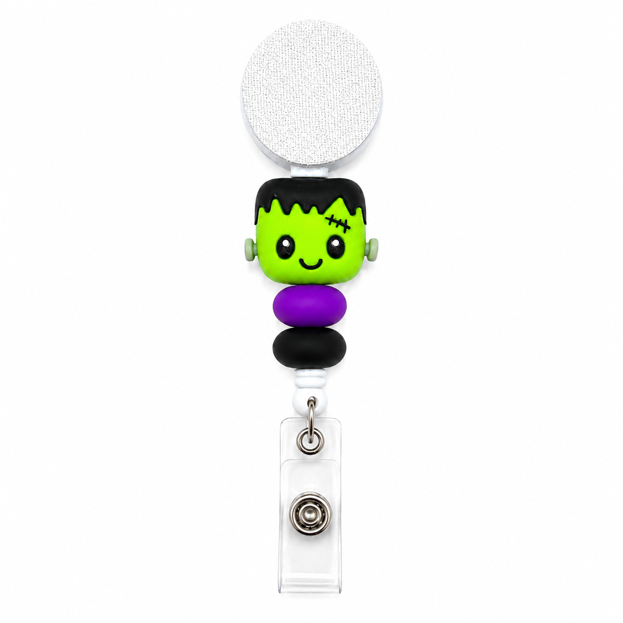 Frankenstein badge reel featuring a cute green Frankenstein monster with black hair, stitched details, purple and black decorative beads, retractable badge reel, and secure badge holder attachment.