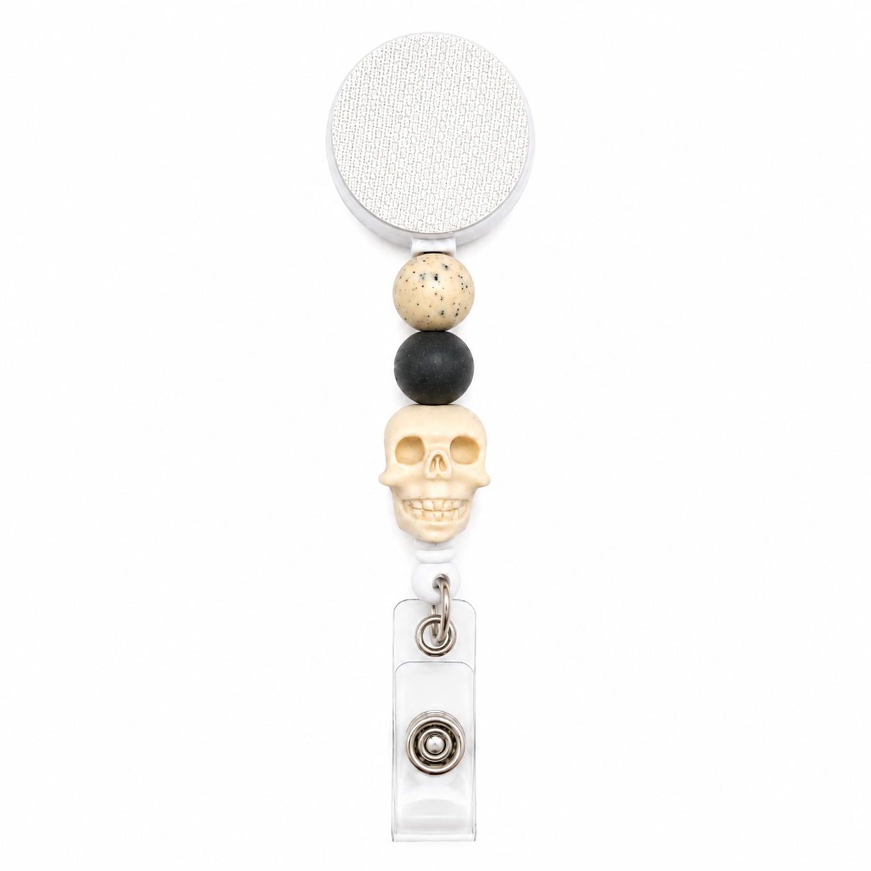 Ghostly Neutral badge reel featuring an ivory skull centerpiece with speckled cream and charcoal black decorative beads, retractable badge reel functionality, and a secure badge holder attachment.