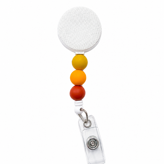 Golden Hour badge reel featuring mustard yellow, orange, and amber decorative beads, retractable badge reel design, and secure badge holder attachment for everyday work use.