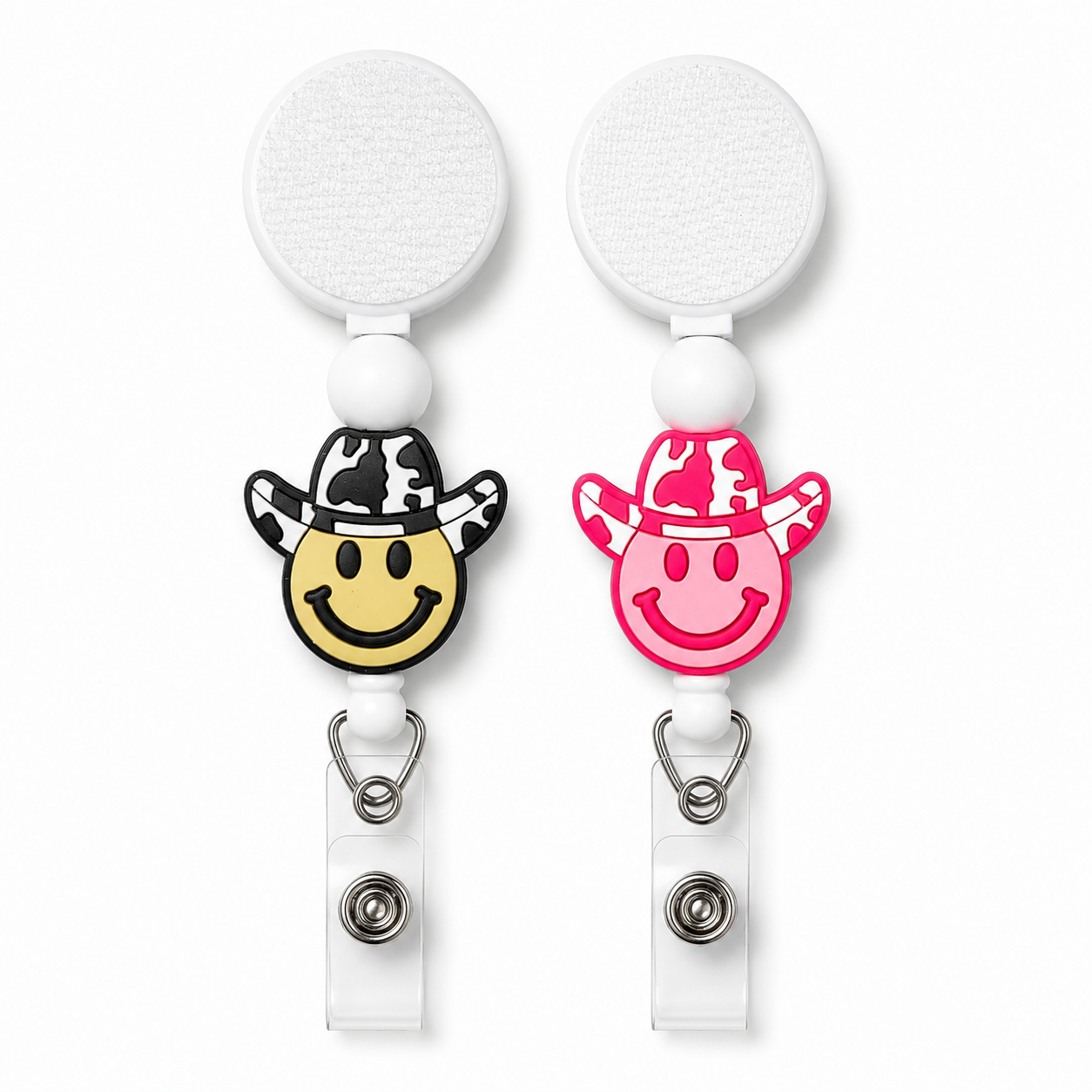 Howdy Smile interchangeable badge reel featuring a smiley face with a black or pink cow print cowboy hat, white bead accent, retractable badge holder, and western-inspired design.