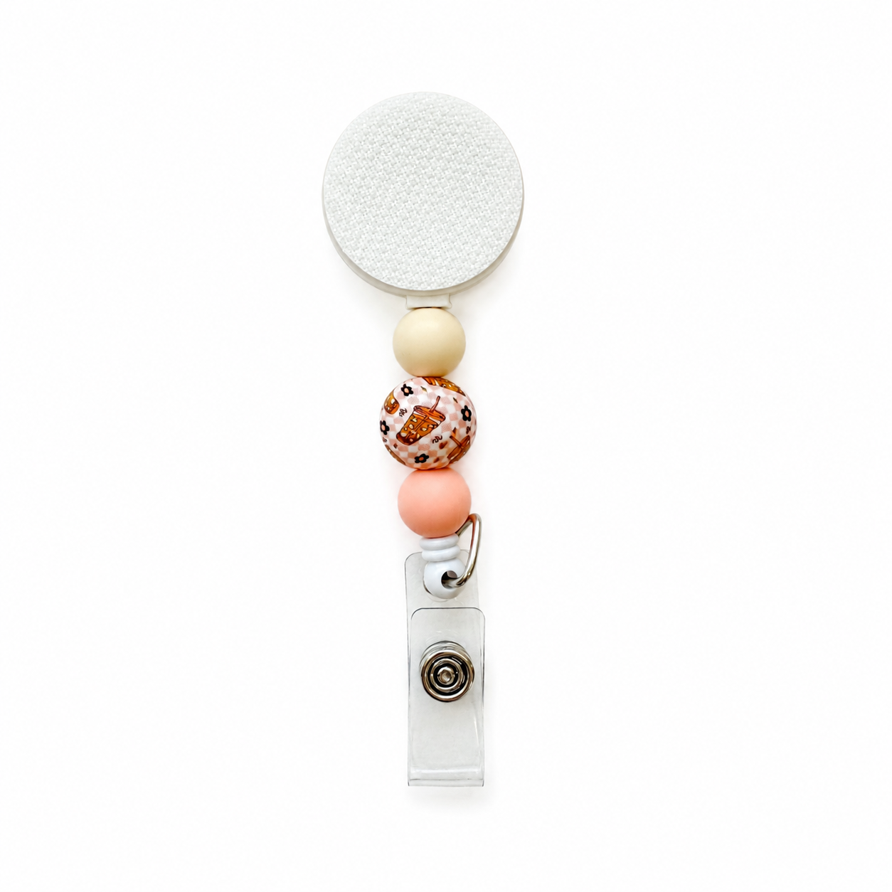 Iced coffee themed beaded badge reel with cream and blush pink silicone beads and a decorative coffee print bead on a white retractable badge reel.