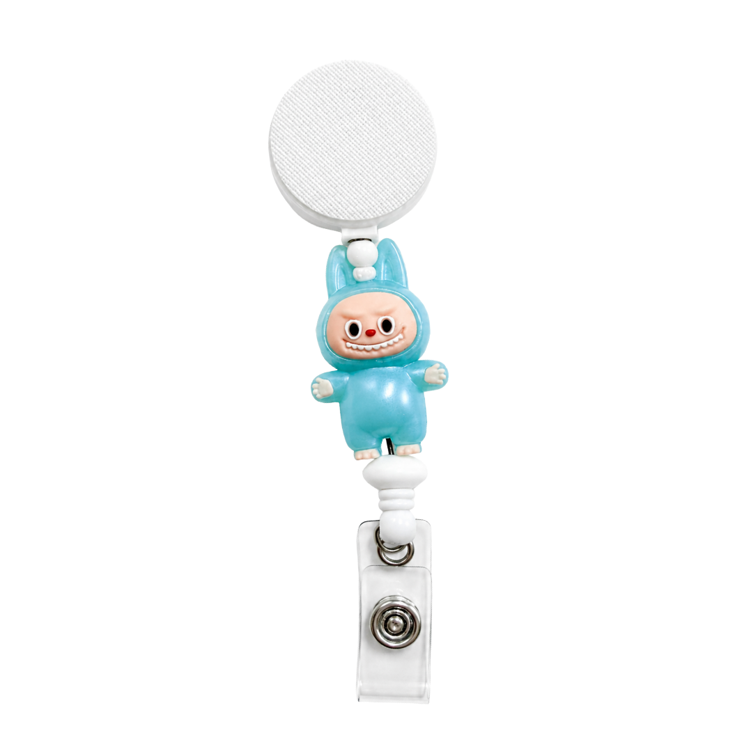 Little Blue Monster badge reel featuring a cute blue character design with white bead accents, retractable badge reel functionality, and a secure badge holder attachment.