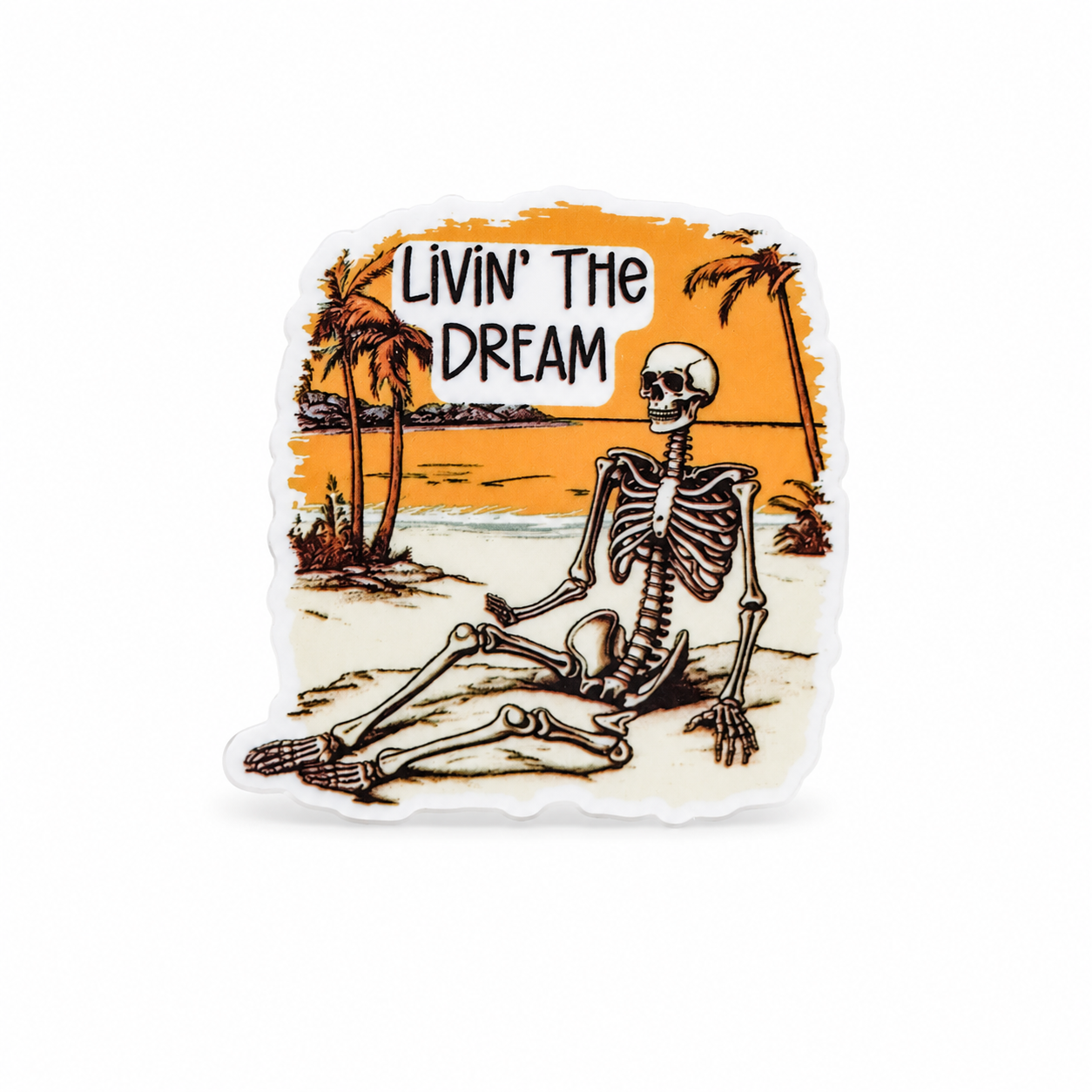 Livin’ The Dream plastic add-on with a skeleton relaxing on a tropical beach, a skeleton lover gift compatible with interchangeable badge reel bases.