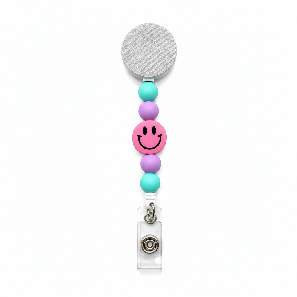 Pink Smiley Face badge reel featuring a pink happy face design with pastel mint and lavender decorative beads, retractable badge reel functionality, and secure badge holder attachment.