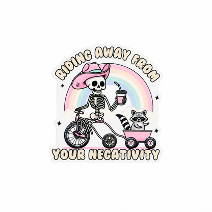 RIDING AWAY FROM YOUR NEGATIVITY plastic add-on featuring a skeleton in a pink cowboy hat riding a bicycle with a raccoon in a wagon under a rainbow, compatible with interchangeable badge reel bases