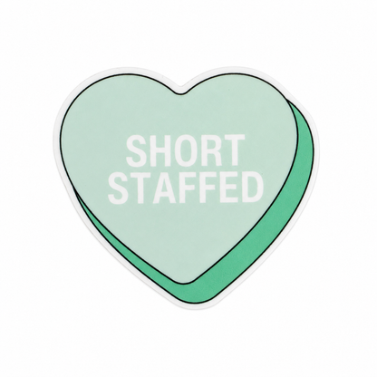 SHORT STAFFED plastic add-on featuring a pastel candy heart design, compatible with interchangeable badge reel bases and perfect for healthcare workers who appreciate relatable workplace humor.