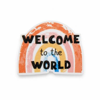 Welcome to the World plastic add-on with a pastel rainbow design, compatible with interchangeable badge reel bases, perfect for newborn baby gifts.