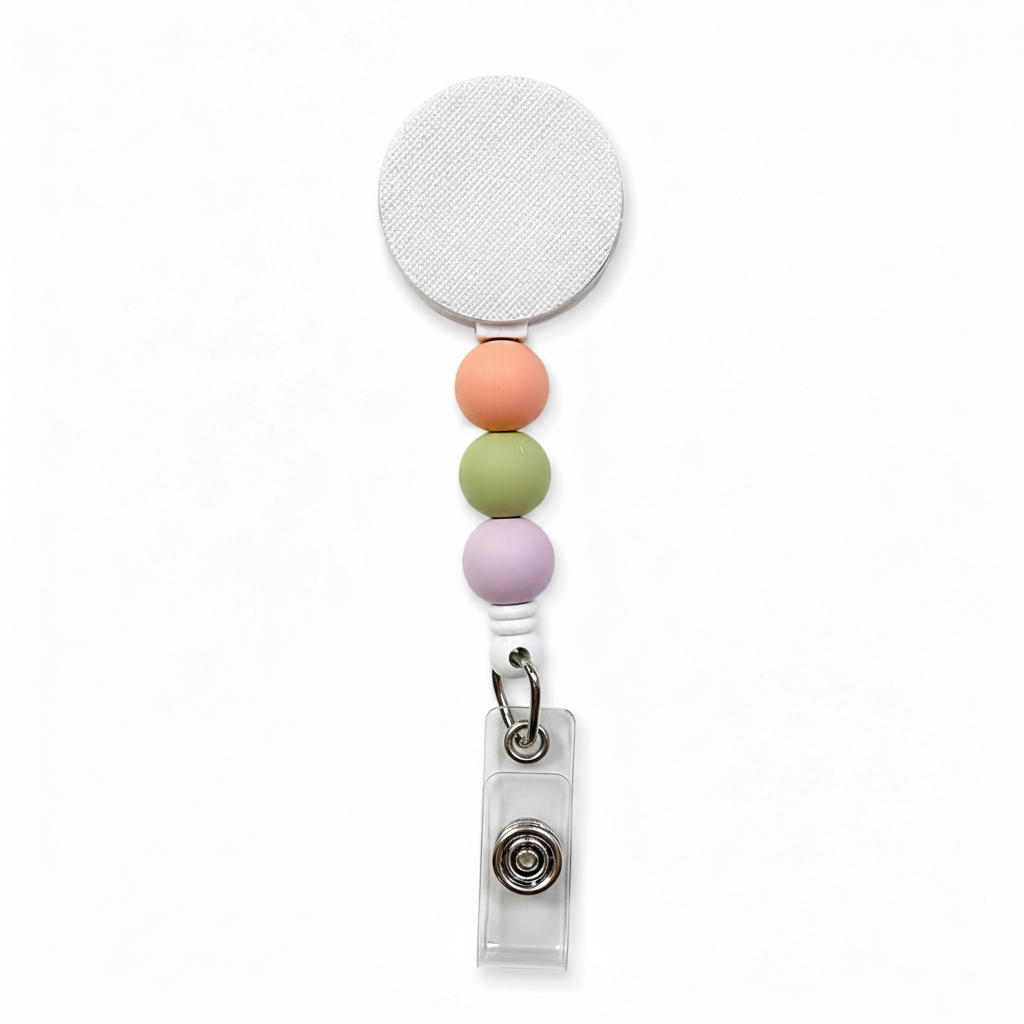 Wildflower fields badge reel featuring soft peach, sage green, and lavender decorative beads on a white retractable badge reel. Minimalist pastel beaded work badge accessory.