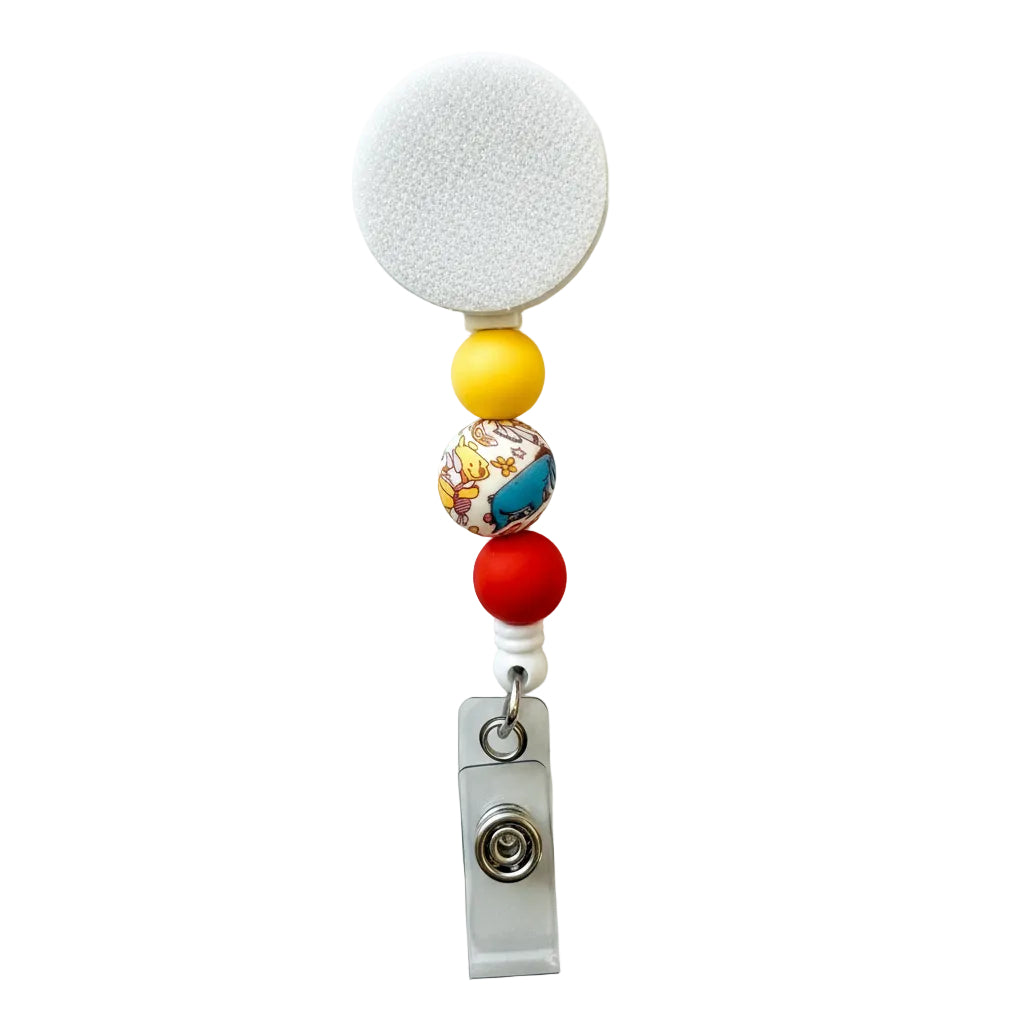 Winnie the Pooh beaded badge reel featuring a colorful illustrated center bead, yellow and red silicone beads, and a retractable ID holder.
